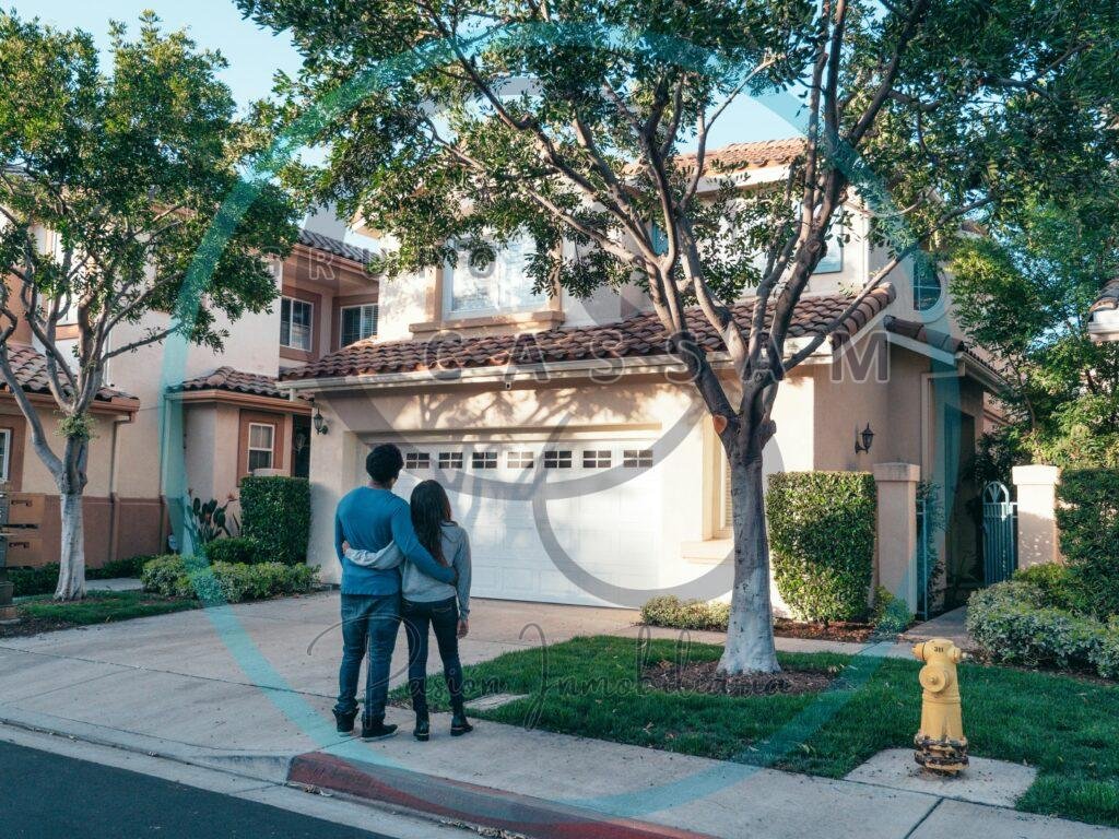 Couple hugging outside their newly purchased suburban home, showcasing togetherness and new beginnings.